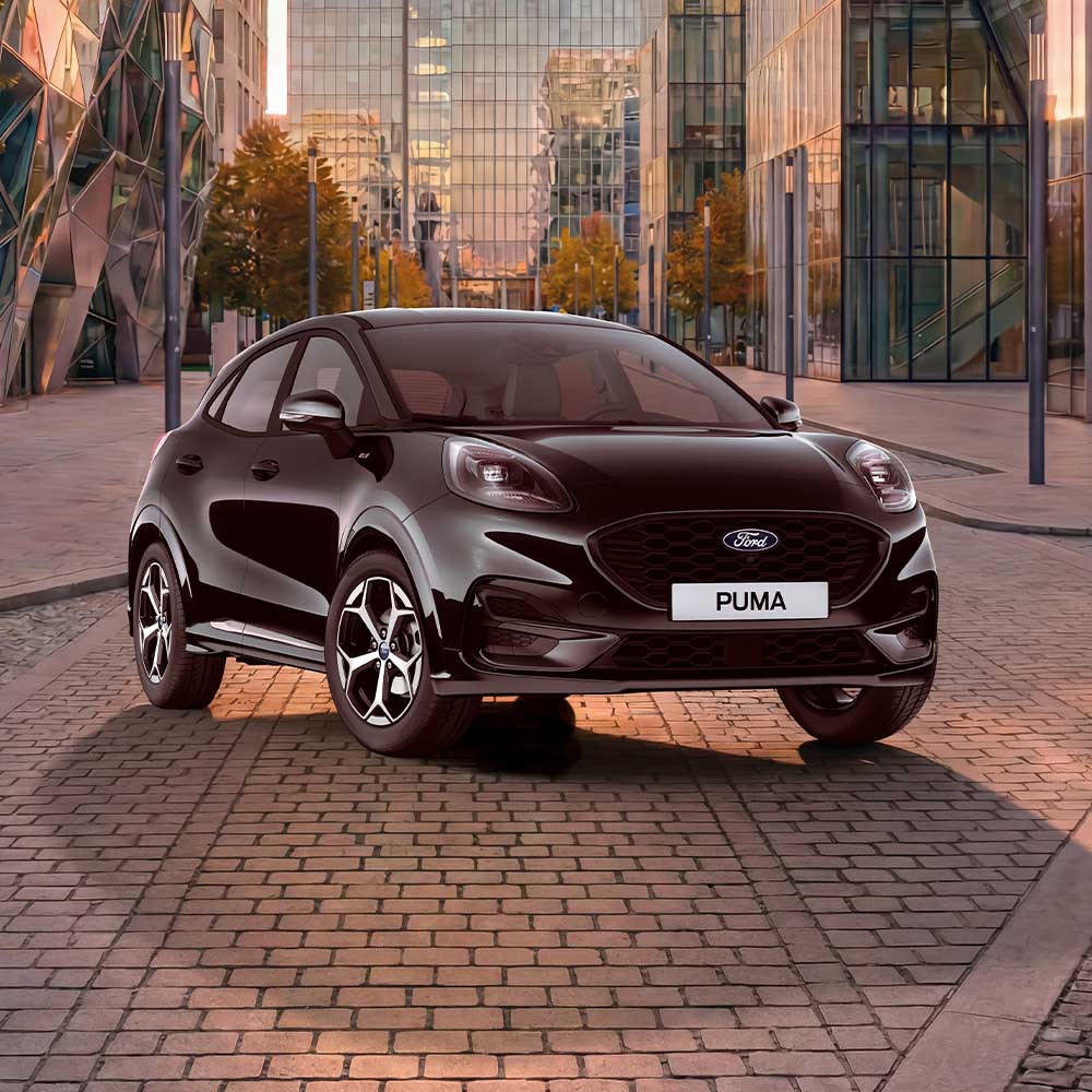 Ford Puma Black Edition in Schwarz, in einer Dreiviertelansicht auf der Straße, mit einem Glasgebäude im Hintergrund.
