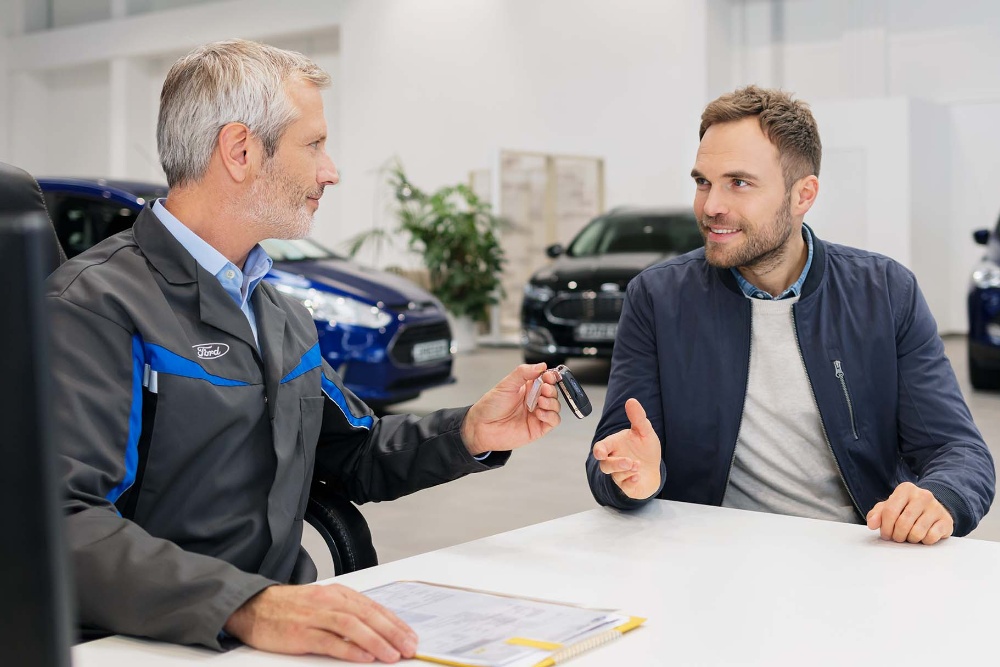 Beratungsgespräch zur Ford Finanzierung für Firmenkunden bei einem Ford-Partner.