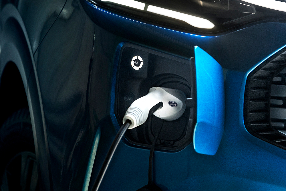 Ford E-Transit Custom in Blau. Detailansicht Ladeanschluss mit Ladekabel.