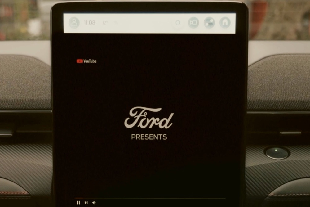 Ein Ford Touchscreen in einem Fahrzeug zeigt das Ford Logo auf schwarzem Hintergrund.