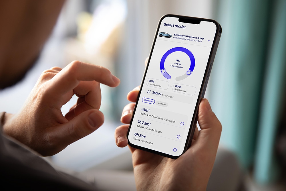 Person hält ein Smartphone in der Hand. Auf dem Display ist der Reichweitenrechner für Elektrofahrzeuge zu sehen.
