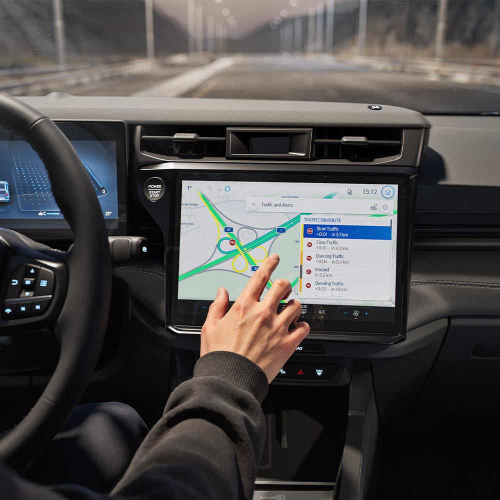 Ein Fahrer bedient Connected-Navigation auf dem Touchscreen im modernen Cockpit einer Ford BlueCruise Edition.