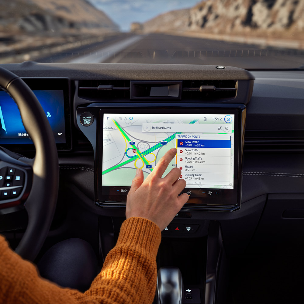 Ein Fahrer bedient Connected-Navigation auf dem Touchscreen im modernen Cockpit einer Ford BlueCruise Edition.