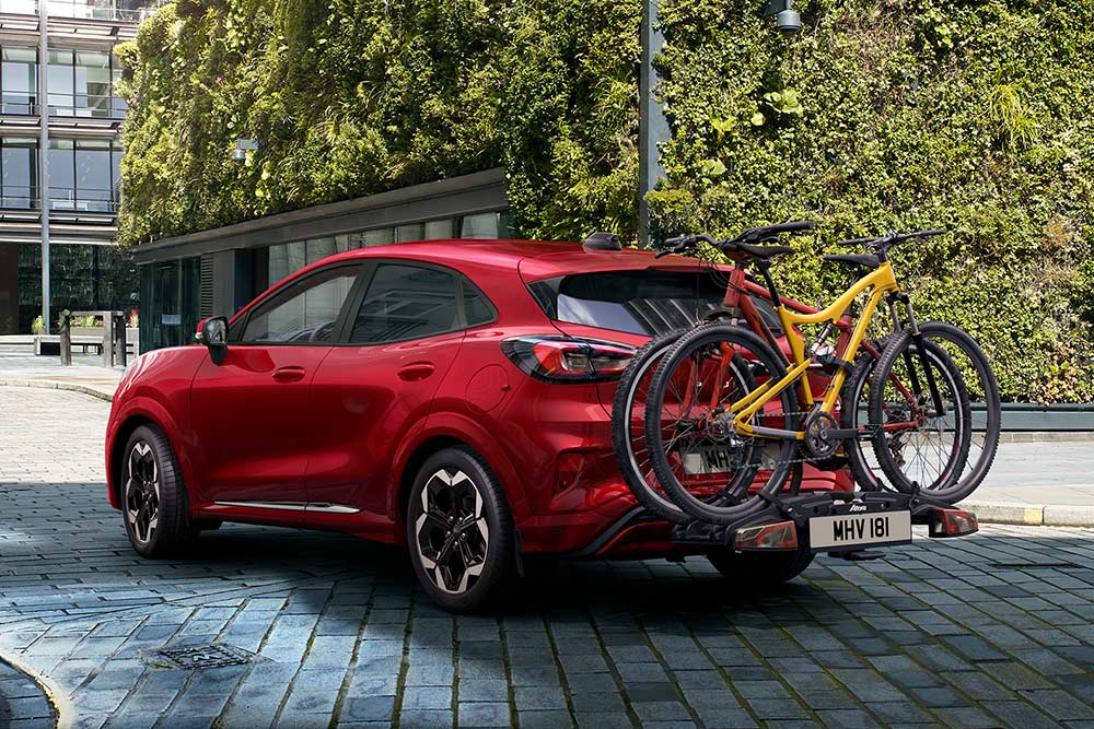Ford Puma in Rot. Dreiviertelansicht vom Heck mit Fahrradträger.