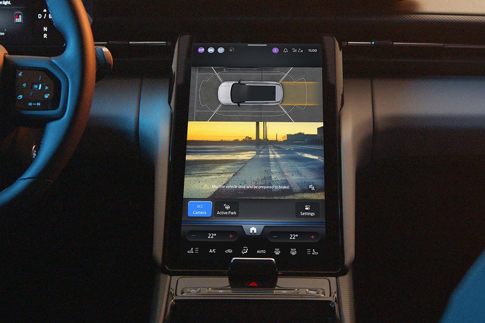 Innenraum eines Ford SUVs mit Fokus auf den digitalen Touchscreen auf dem der aktivierte Active-Park-Assist zu sehen ist.