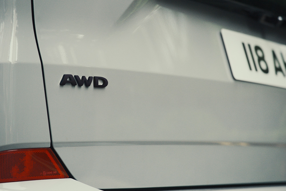Ford Tourneo Custom in Weiß. Detailansicht AWD-Logo am Heck.