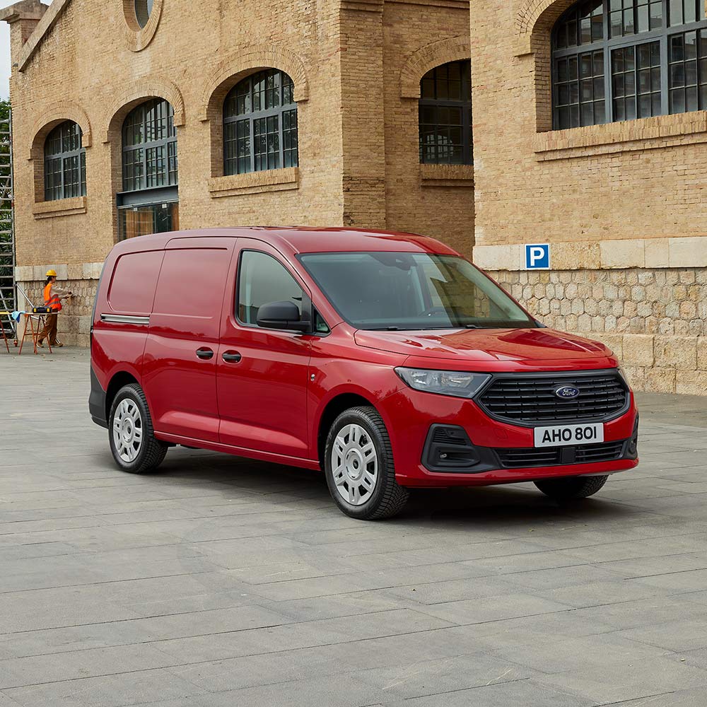 Ford Transit Connect in Rot. Dreiviertansicht, parkt vor einem Backsteingebäude.