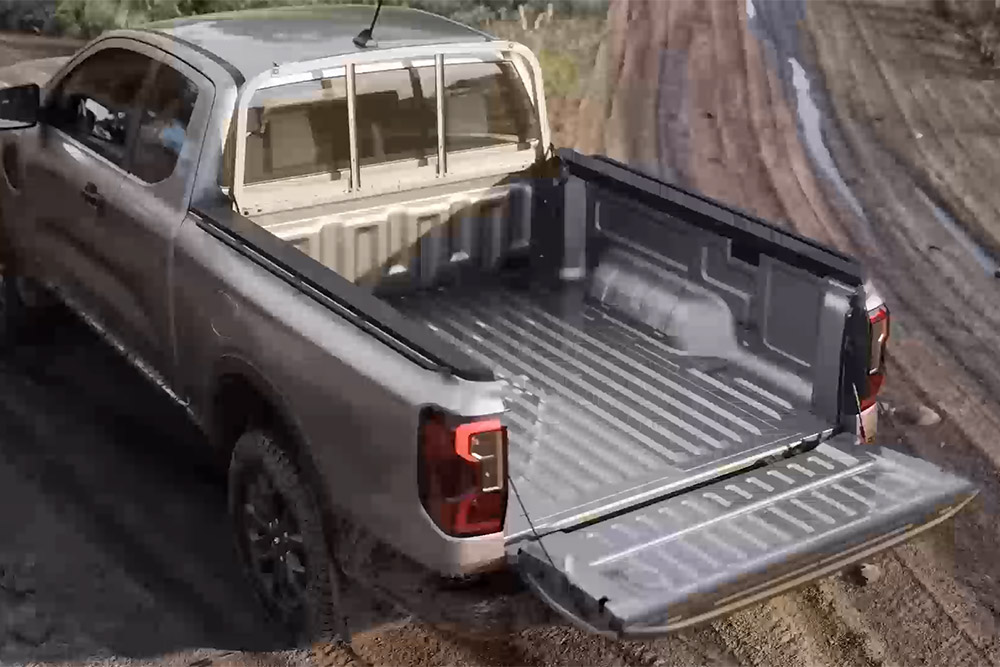 Ford Ranger Extrakabine in Silber. Dreiviertelansicht von hinten mit geöffneter Heckklappe.