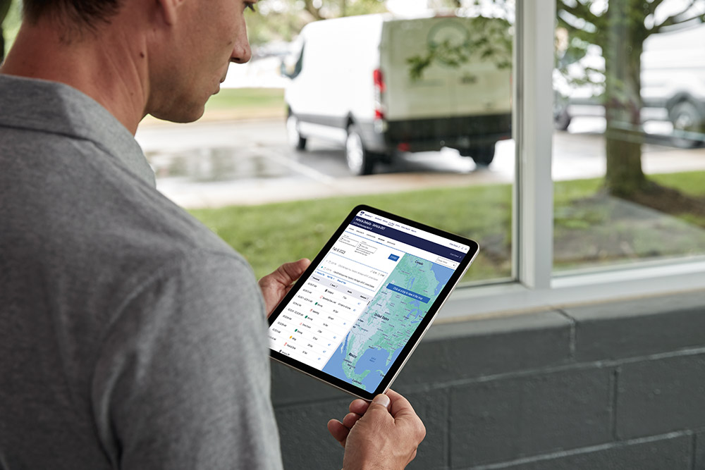 Mann betrachtet seine Ford-Fahrzeugdaten auf einem Tablet mit Ford Pro Telematics.