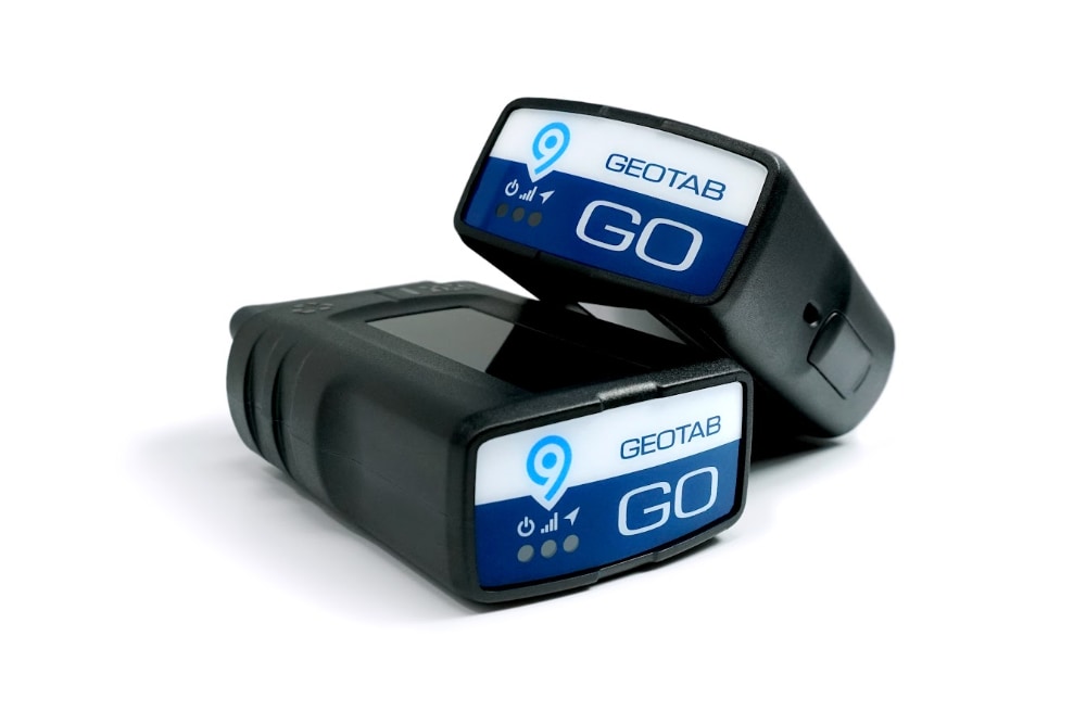 Zwei Geotab GO 9 Telematics-Geräte zur Fahrzeugdatenerfassung vor einem weißen Hintergrund.