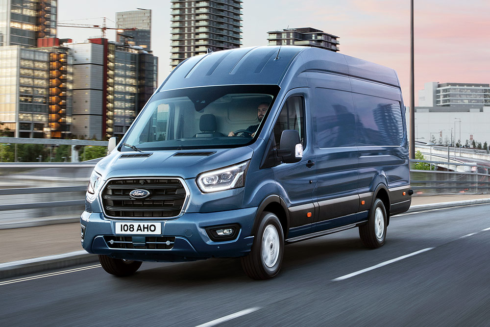 Ford Transit in Blau. Dreiviertelansicht, fahrend auf einer Straße.