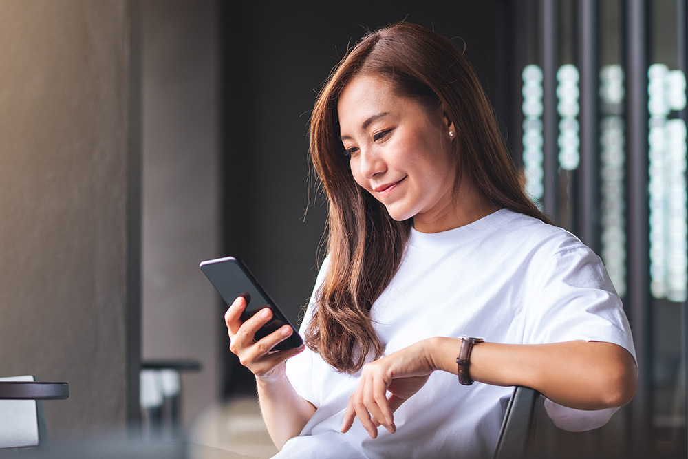 Person überprüft Echtzeit-Benachrichtigungen von der Ford App auf ihrem Smartphone.