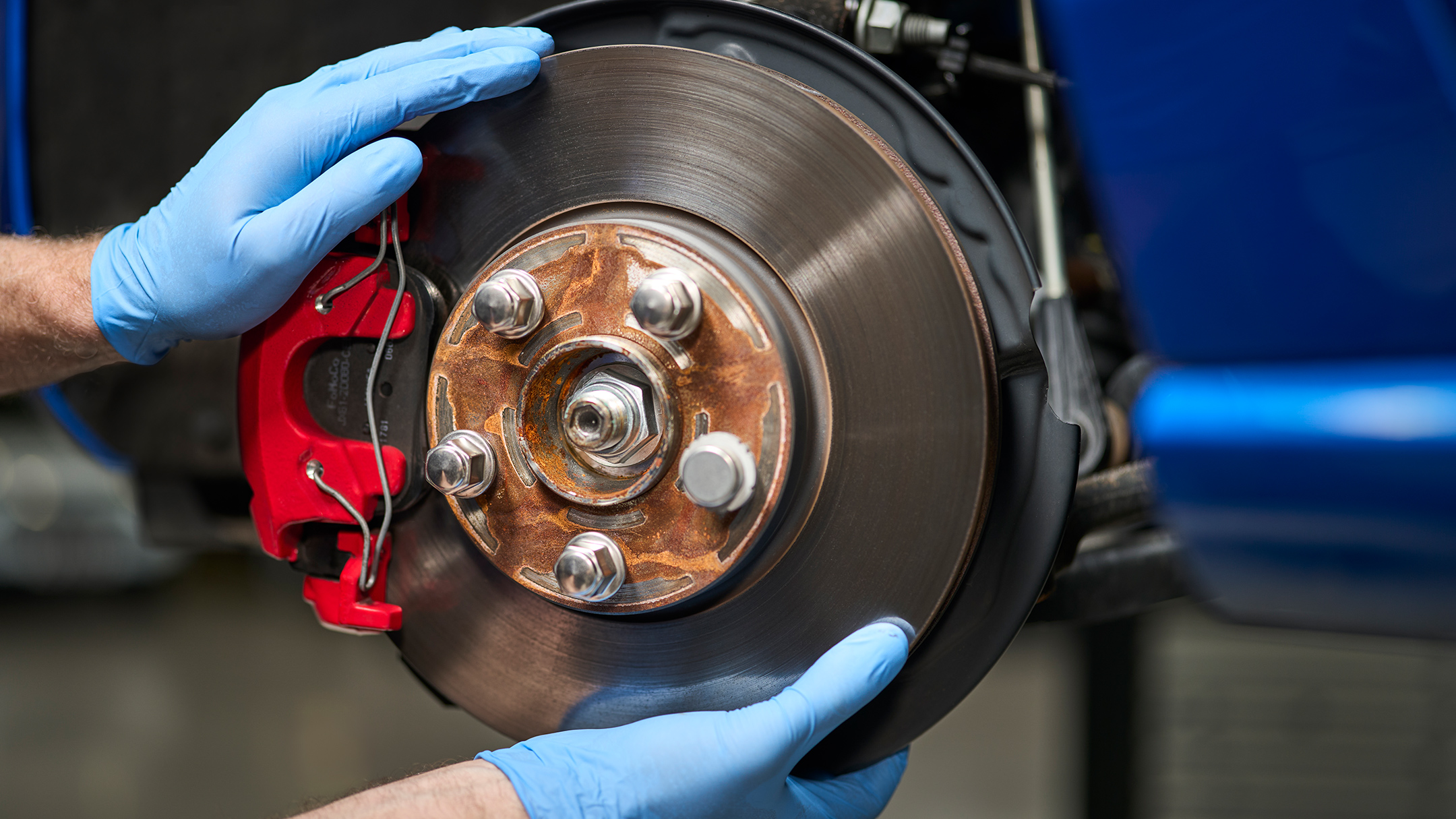 Ein Ford Mechaniker hält eine originale Ford Bremsscheibe in den Händen. 
