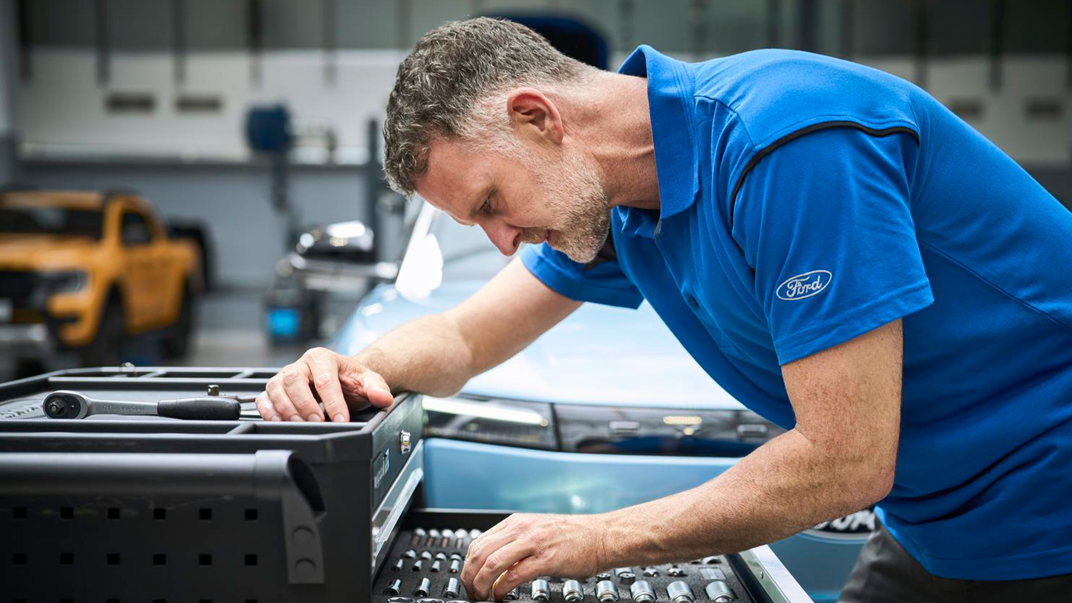 Eine Ford Pro Expertin checkt auf ihrem  Laptop während des Ford Services Fahrzeugdaten.